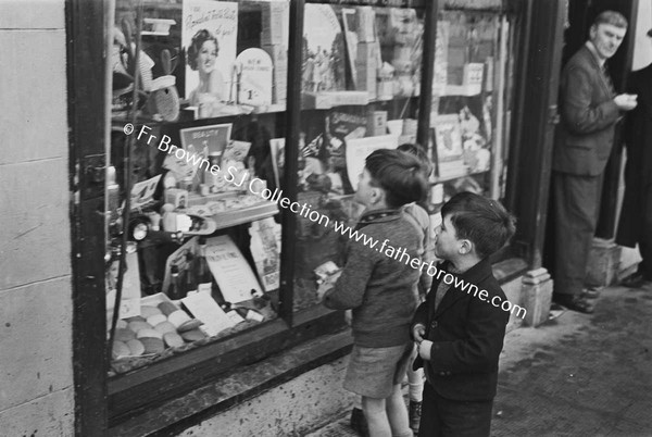 CHILDREN LOOKING IN SHOP WINGOW